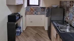 A compact kitchen with a window, tiled backsplash, and a sink. - La Pergola Apartment near Historic Ballarò Market (Palermo)