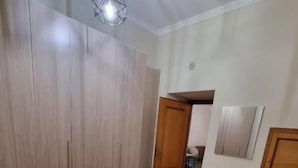 A bedroom with a bed, a wardrobe, and a mirror. - La Pergola Apartment near Historic Ballarò Market (Palermo)