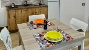 Uma cozinha compacta com armários de madeira, micro-ondas e geladeira.