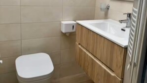 Une salle de bain moderne avec des toilettes, un lavabo et un miroir.