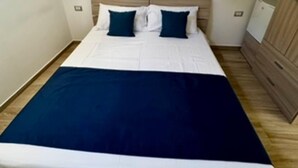 Une chambre à coucher avec un lit, une armoire en bois et une lucarne.