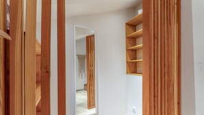 Ein Korridor mit Holzwandverkleidung, einem Spiegel und einem eingebauten Regal.
