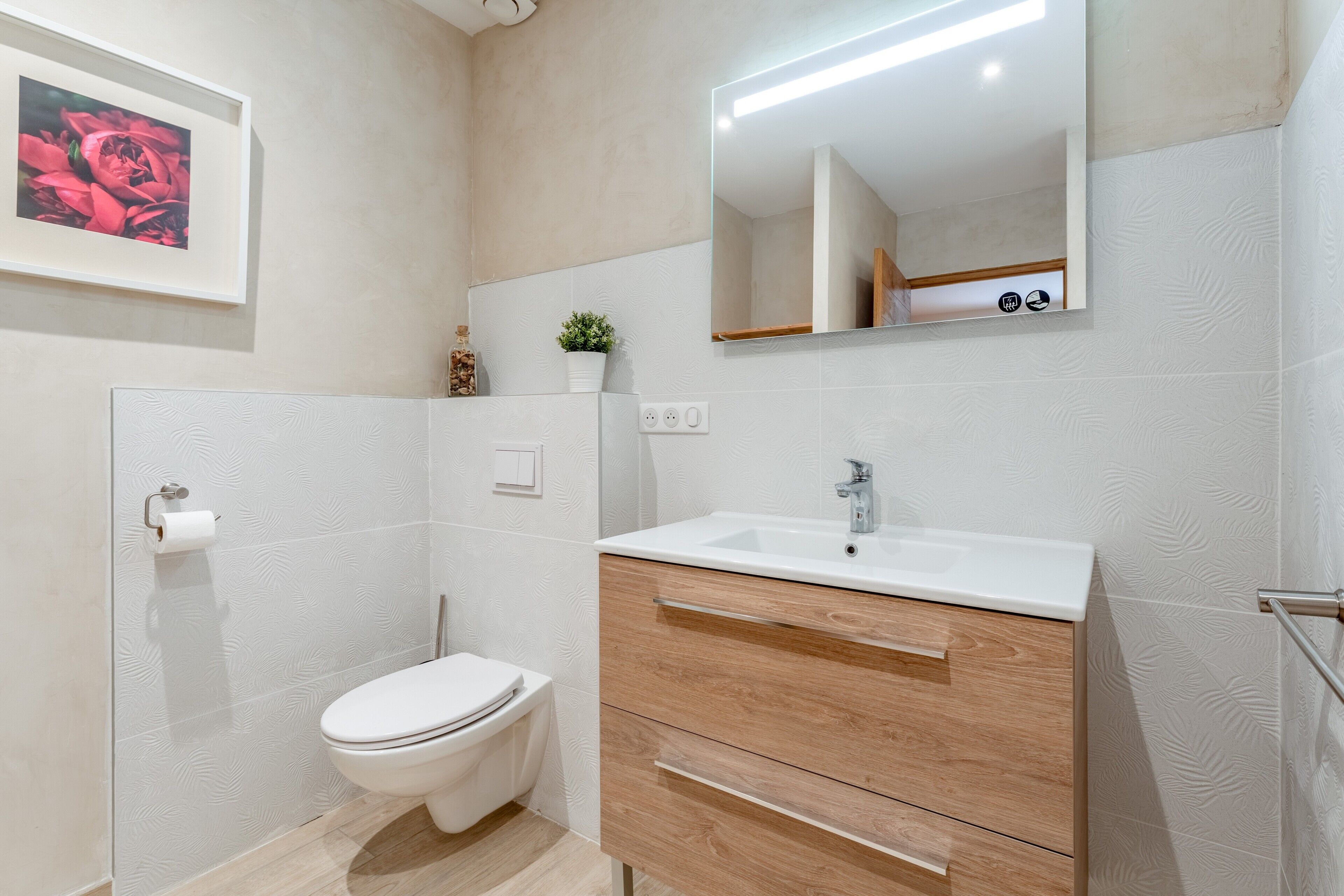 Un baño moderno con inodoro, lavamanos y tocador de madera.