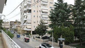 Ein weißer SUV parkt auf einer Straße in einem Wohngebiet, im Hintergrund ist ein Mehrfamilienhaus zu sehen.