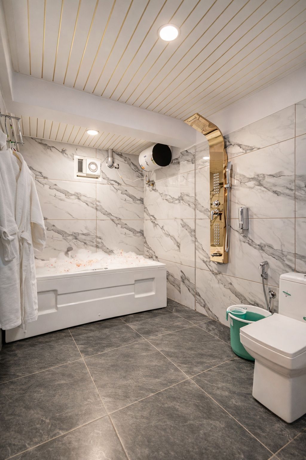 A modern bathroom with a marble wall, a bathtub, a toilet, and a shower area.