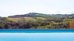 Une piscine avec vue sur les vignes et les collines environnantes.