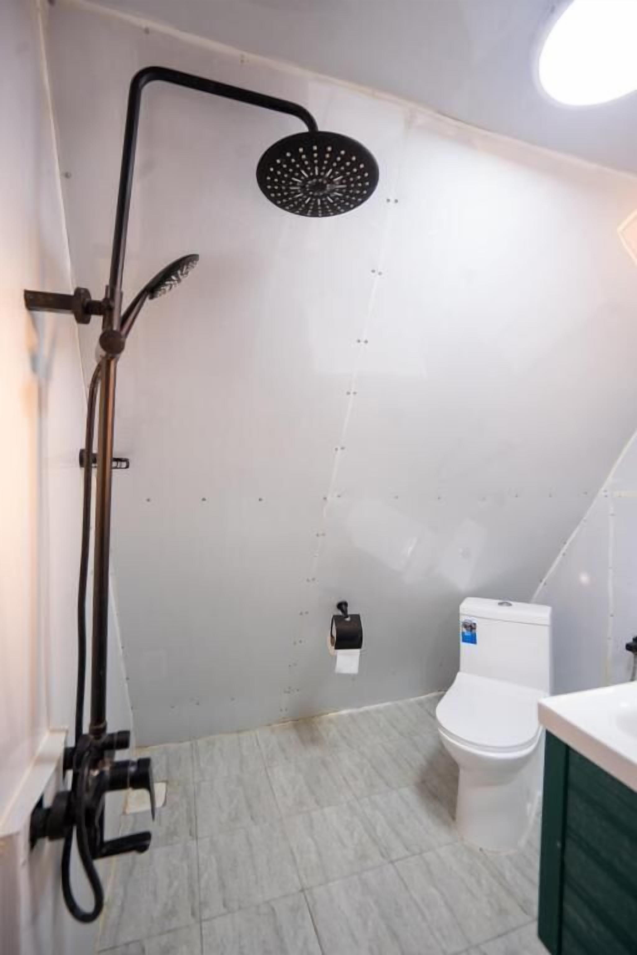 A bathroom with a shower, toilet, and sink.