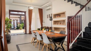A modern dining area with a wooden table, grey chairs, and a staircase with a wooden railing. - 2 Bedrm Villa+ Living Room, 15 mins walk to Center (Krong Siem Reap)