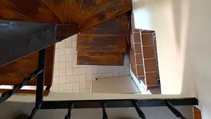 Eine Treppe mit Holzgeländer und Ziegelwand.
