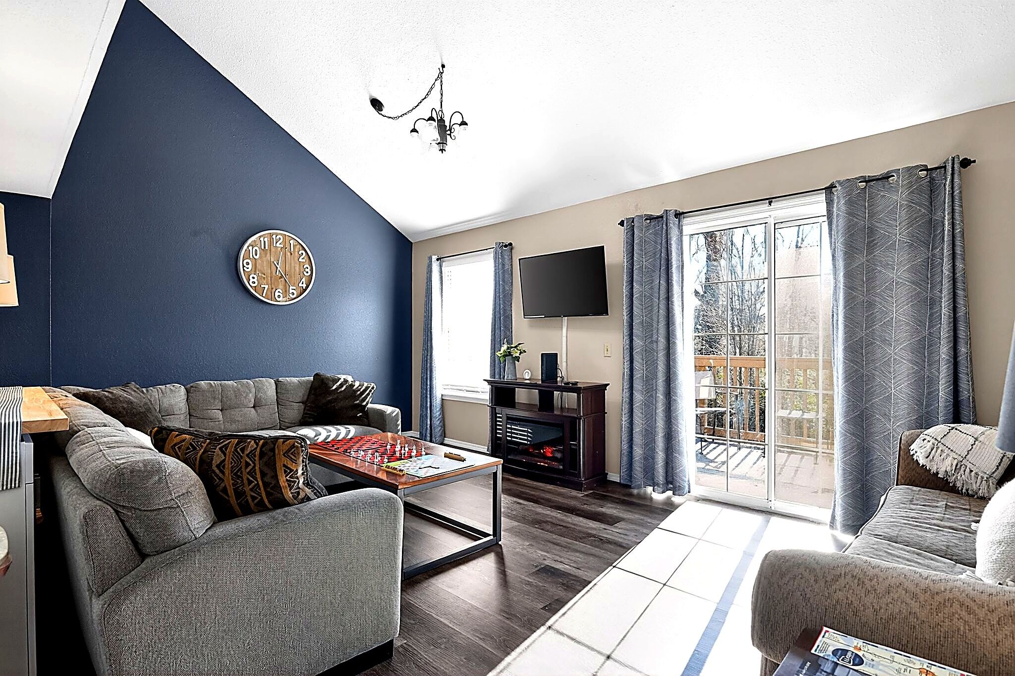 A living room with a sofa, a coffee table, a flat-screen TV, and a fireplace.