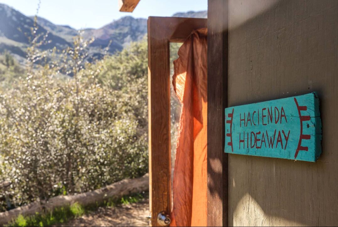 A wooden door with a sign reading "Hacienda Hideaway".