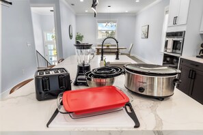 A modern kitchen with a toaster, blender, crockpot, and a red baking dish on the counter. - Beach Getaway - Ask about Special Monthly Rates (Hernando Beach)