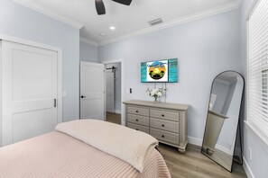 A bedroom with a bed, dresser, mirror, and a wall-mounted TV. - Beach Getaway - Ask about Special Monthly Rates (Hernando Beach)
