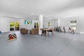 A spacious indoor area with a pool table, seating, and bicycles. - Beach Getaway - Ask about Special Monthly Rates (Hernando Beach)