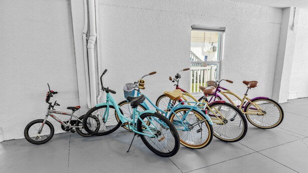 A row of bicycles parked against a white wall in a room with a large window. - Kayaks/LocatedonCanal/Sunsets/HeatedPool (Hernando Beach)