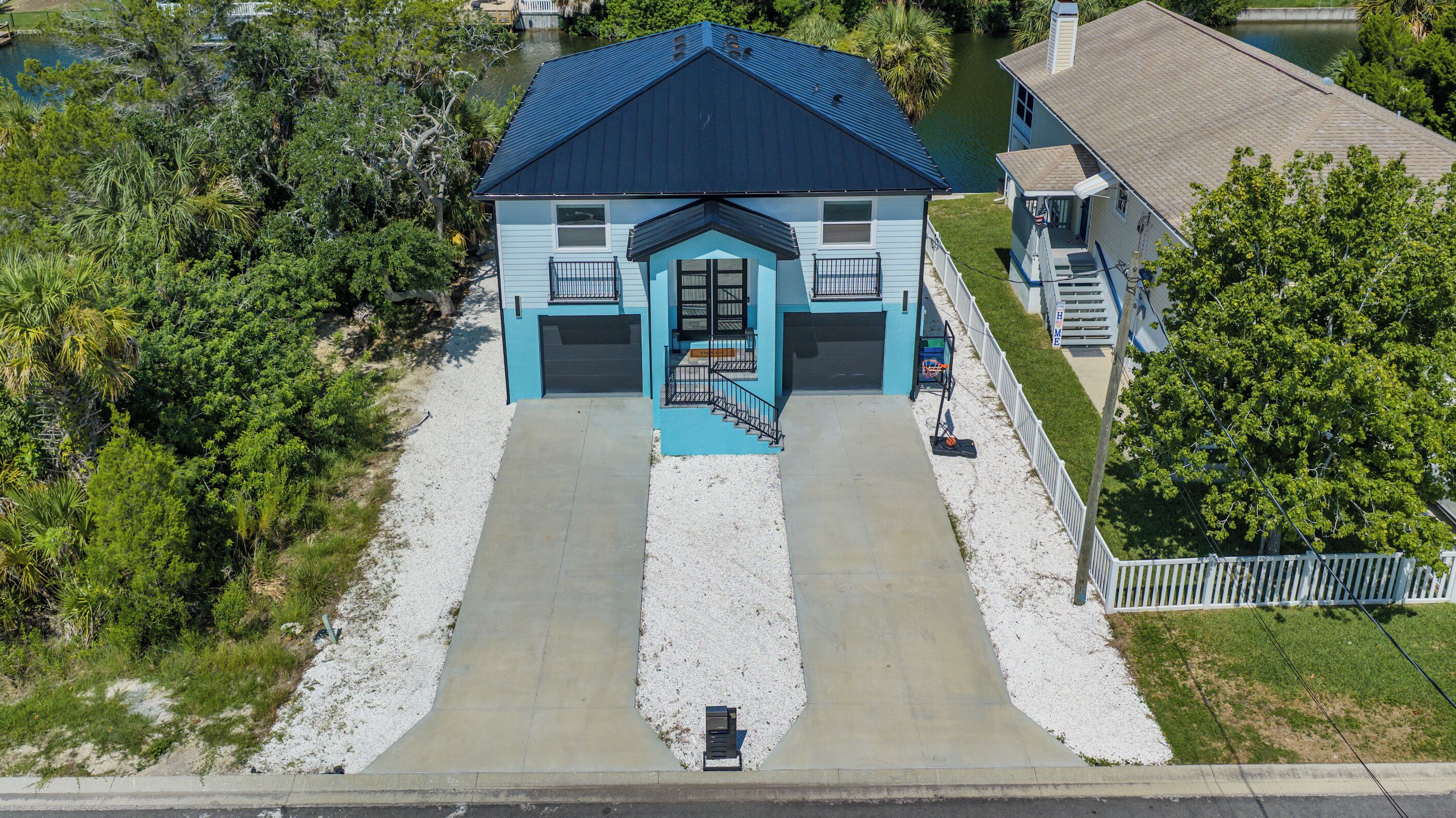 A two-story house with a blue roof and a front entrance with a small porch.