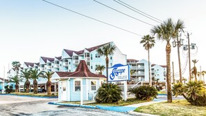 A resort with multiple buildings, palm trees, and a sign for 'Eaglecrest Resort Rental Condominiums'.