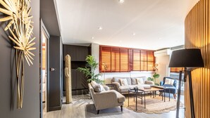 Een moderne woonkamer met een hoekbank, een salontafel en een lamp.