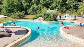 Una piscina al aire libre de temporada, sombrillas