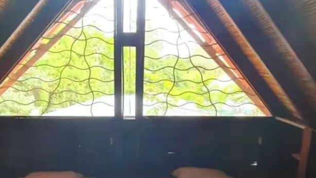 Une petite chambre confortable avec deux lits et une grande fenêtre.