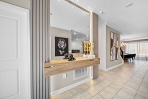 Ein modernes Interieur mit einem Holzbüro, einem großen Spiegel und Kunstwerken an den W änden.