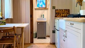 A kitchen with wooden cabinets, a built-in oven, and a window with a diamond-patterned glass.