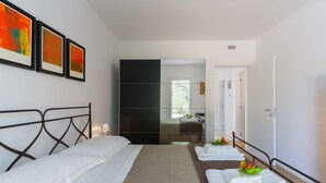 A hotel room with a bed, a mirror, a wardrobe, and a bathroom visible through an open door. - Ecovilla Terra di Luce with Private Pool (Martina Franca)