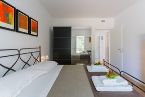 A hotel room with a bed, a mirror, a wardrobe, and a bathroom visible through an open door. - Ecovilla Terra di Luce with Private Pool (Martina Franca)