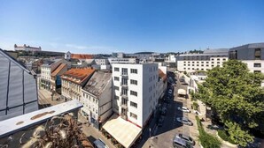 En stadsbild med en blandning av moderna och traditionella byggnader, en klar himmel och en parkeringsplats.