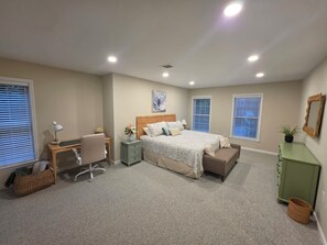 A bedroom with a bed, desk, chair, bedside tables, and a green cabinet. - Irene's Hideaway (Tisbury)