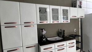 A kitchen with white cabinets, a black countertop, and a blender on the counter.