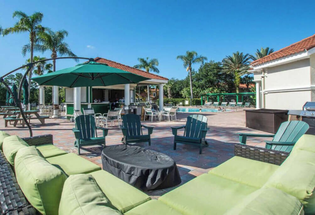 A poolside area with lounge chairs, a covered seating area, and a pool.