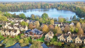A residential area with houses near a lake, featuring a mix of traditional and modern architecture. - Mill Village 71/72, Milly Cottage - Lakeside, Onsite Facilities, Pool, Sleeps 11 (Somerford Keynes)