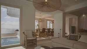 Un salon moderne doté d’une grande fenêtre, d’un coin repas et d’un espace salon confortable.
