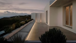Un bâtiment moderne doté d’un toit plat, de grandes fenêtres et offrant une vue sur le paysage.
