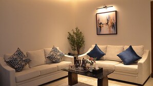 Uma sala de estar com dois sofás, uma mesa de centro e um quadro na parede.
