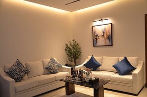Ein Wohnzimmer mit zwei Sofas, einem Couchtisch und einem Gemälde an der Wand.