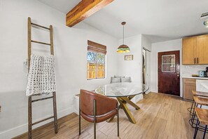 A compact kitchen with a wooden ceiling, a glass dining table, and a brown leather chair. - Charming 3-bedroom house with AC in sunny Phoenix (Phoenix)