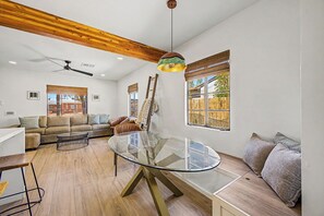 A spacious living room with a glass-top dining table, a wooden ceiling, and a view of the outside. - Charming 3-bedroom house with AC in sunny Phoenix (Phoenix)