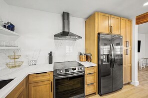 Eine moderne Küche mit einem Edelstahl-Kühlschrank, Backofen und einer Gasherd.