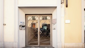 A building entrance with a metal gate, a mailbox, and a utility box. - Casa Sorelle Flo - Flo Apartments (Florence)