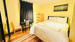A hotel room with a bed, a desk, a chair, and a wardrobe. - Fabulous Apartment Near Central London (London)