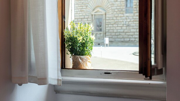 A window with a view of a building with arched windows and a stone facade. - Pitti - Flo Apartments, Charme su Piazza Pitti (Florence)
