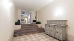 A staircase leading to a second floor, a light-colored wall, and a large, ornate cabinet. - Boboli - Flo Apartments (Florence)