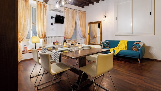 Un coin repas avec une table en bois, des chaises et un canapé bleu.