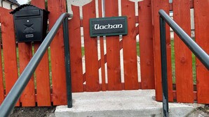 Un cancello di legno rosso con una targa che riporta la scritta "Uochan" e una cassetta delle lettere nera a sinistra.