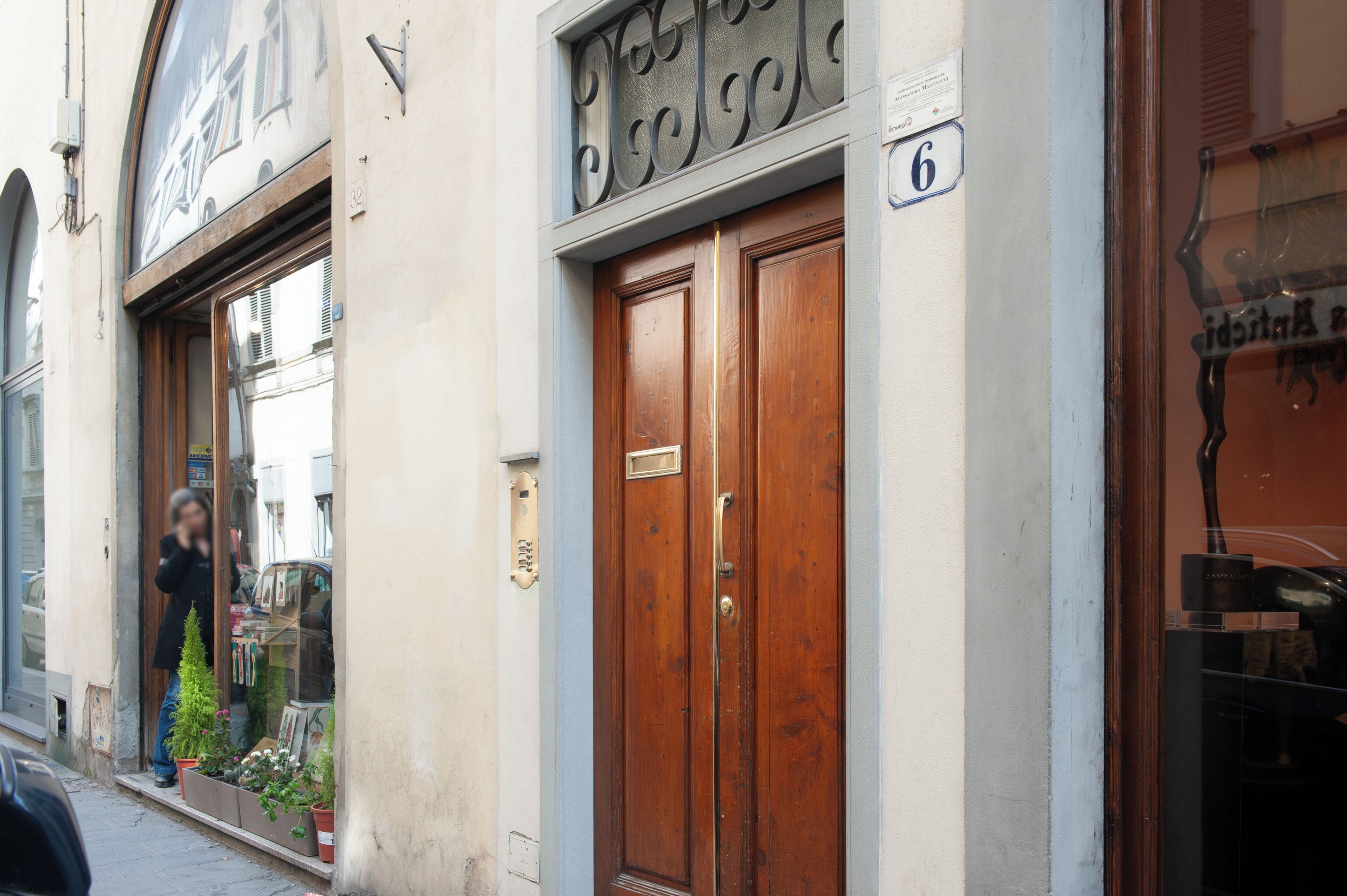 A building with a wooden door and a window with a metal grill.