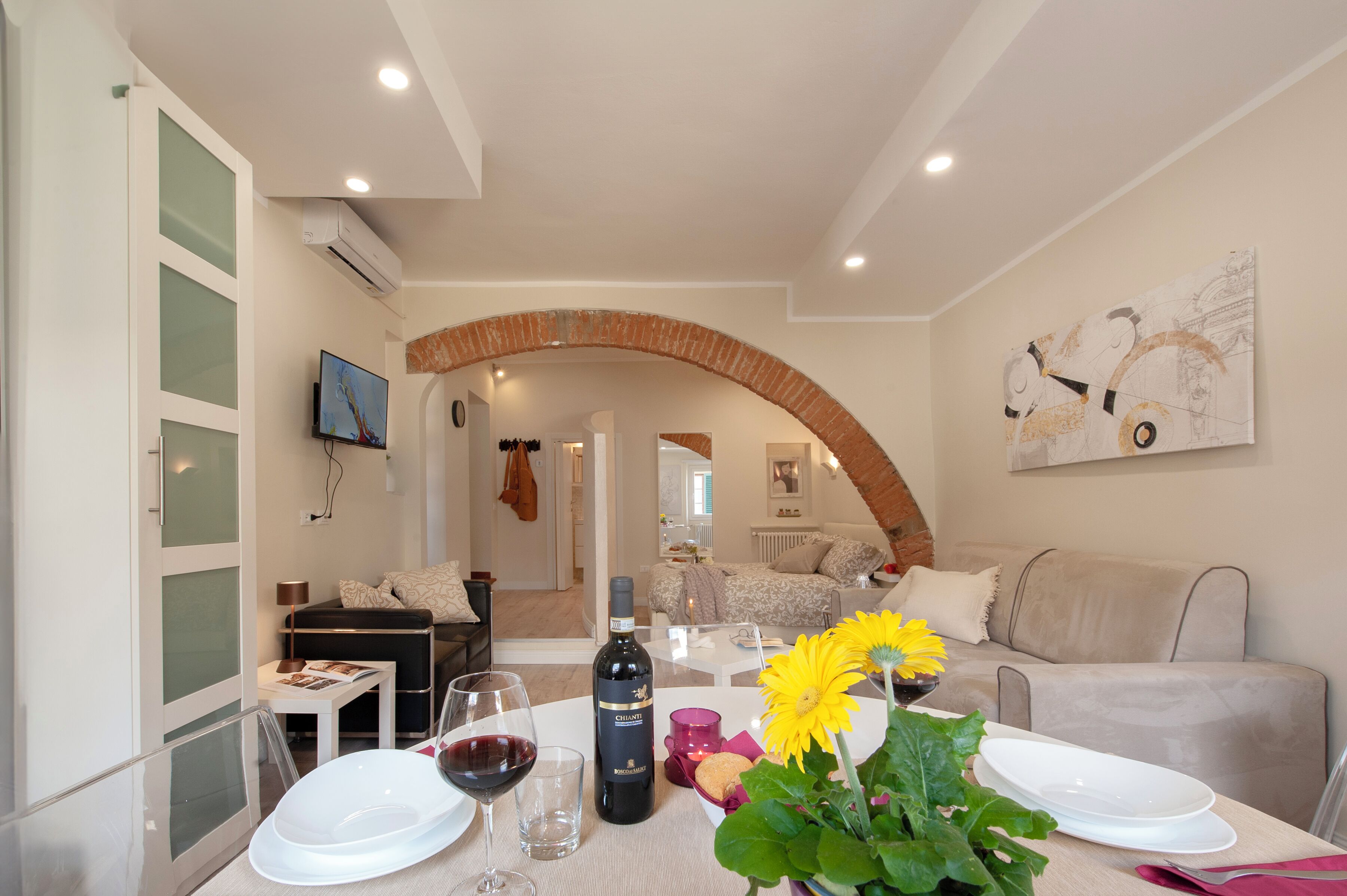 A modern living room with a dining area, a fireplace, and a television.