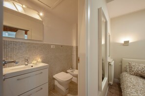 A bathroom with a toilet, sink, and mirror. - Fossi - Flo Apartments (Florence)