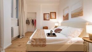Una camera da letto ordinata con un letto, un comodino e una finestra con tende.